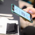 Up close to hand holding cell phone using a Comcast QR code